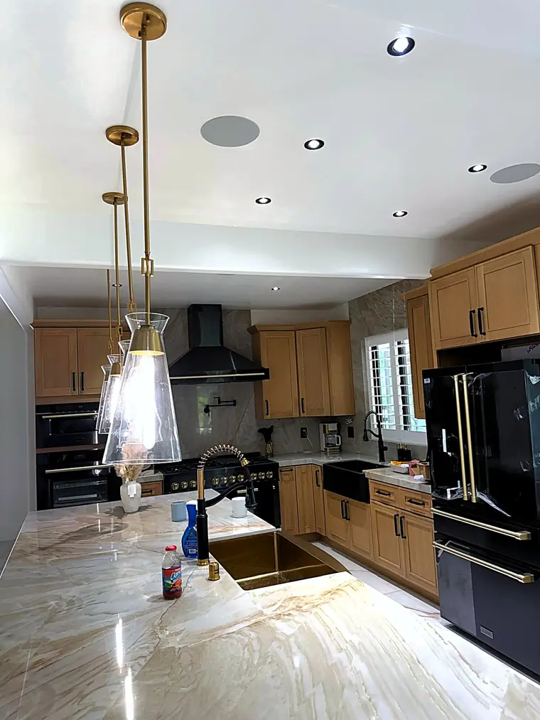 Pendant bar lights and recessed lighting installed in a remodeled kitchen