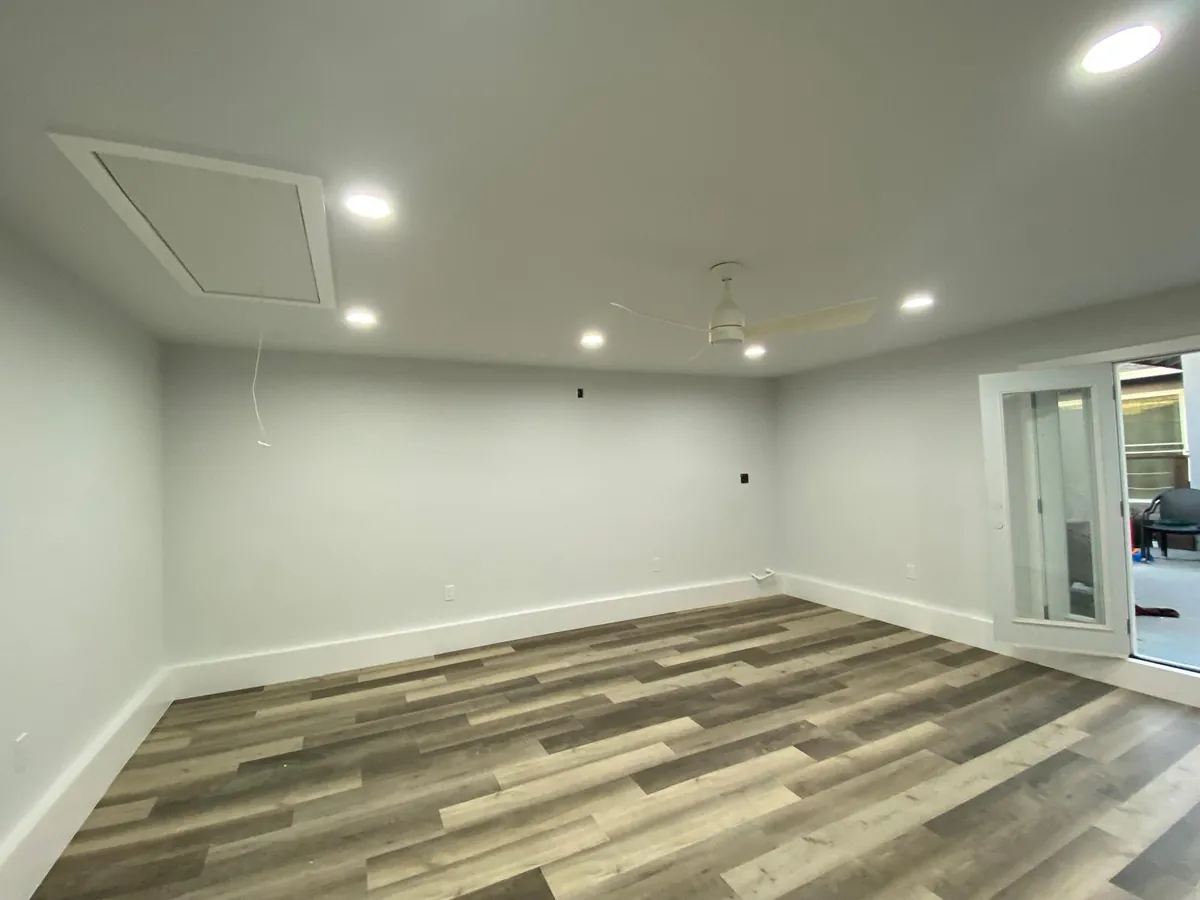 Finished room with new recessed lighting and a ceiling fan