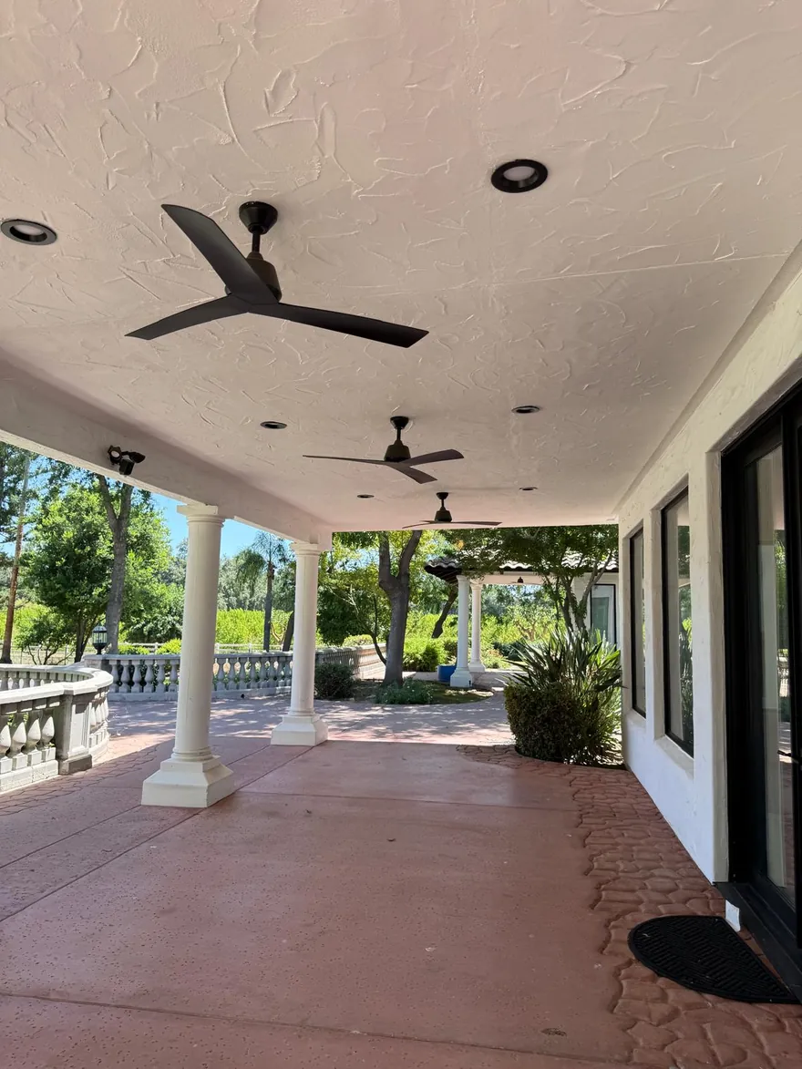 Large covered patio with columns, ceiling fans, and recessed lighting