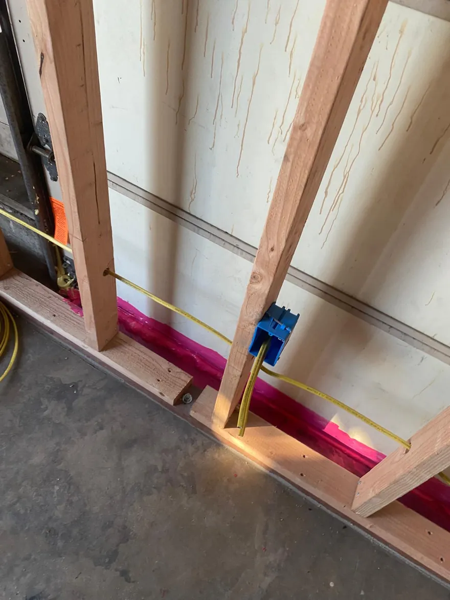New wiring pulled through framed walls on a new construction project