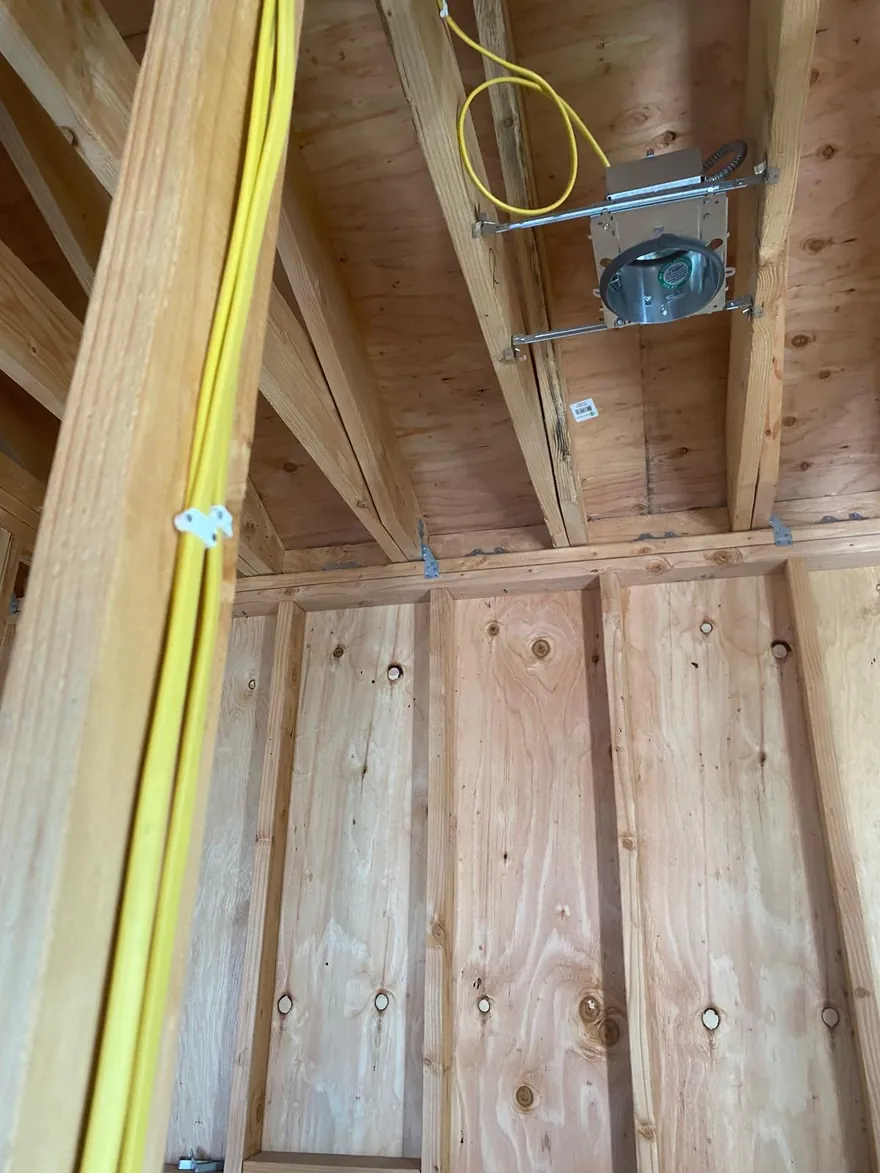 New wiring and recessed light cans roughed in through open framing during a whole house rewire